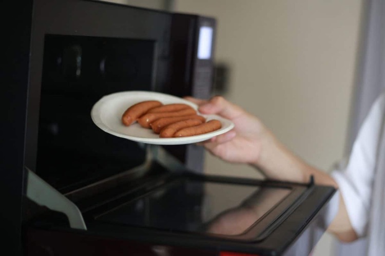 A man who arranges wieners on a paper plate and tries to heat them in the microwave 1200x800 2